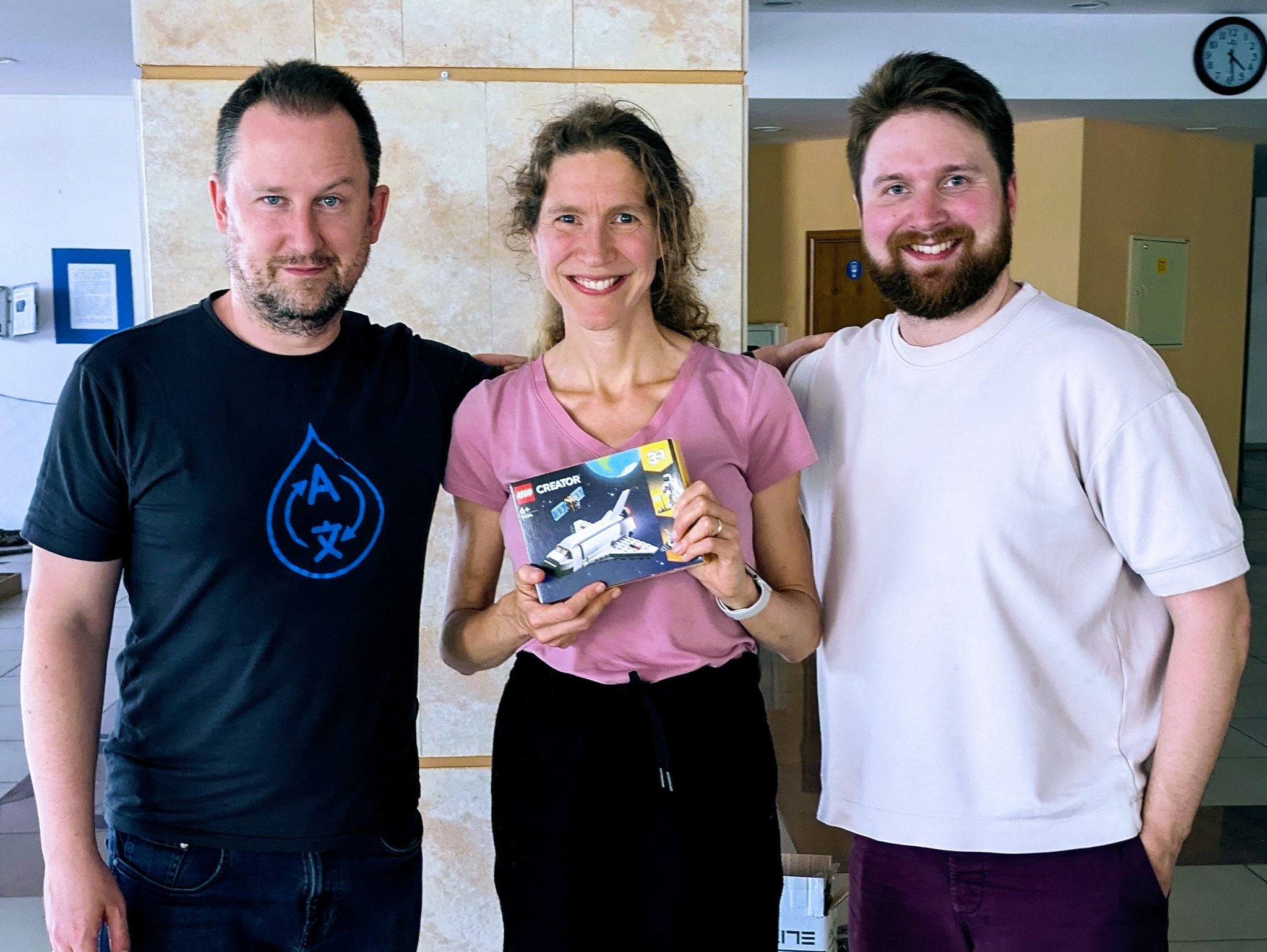 Drupalists Gabor and Lauri presenting Suzanne with her award for the best Starshot contribution - a Lego Spaceship set.